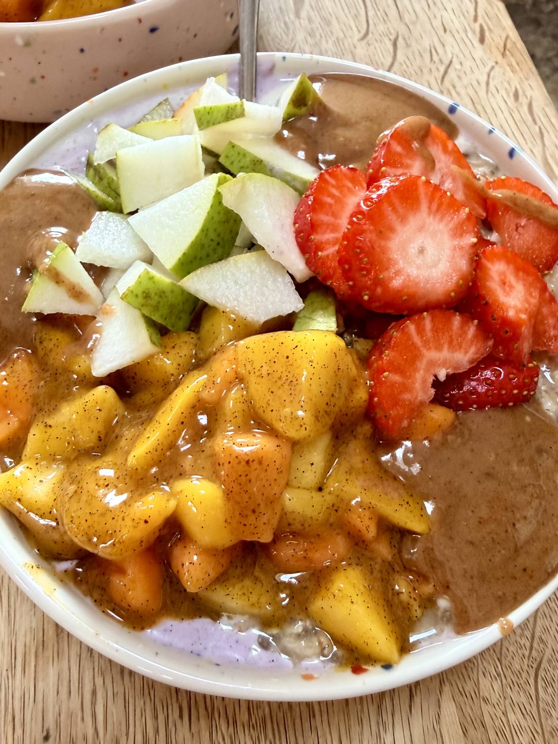 Bircher Premium: Overnight Oats mit Rosinen unter goldener Amlou-Creme und Saisonobst