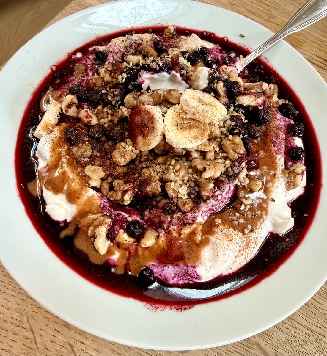 Nordic Blue Bowl: lila Skyr-Creme mit wilden Heidelbeeren, Banane und Walnüssen in heller Schale
